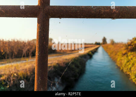 Brücke über einem bewässerungskanal der Lomellina bei Sonnenuntergang Stockfoto