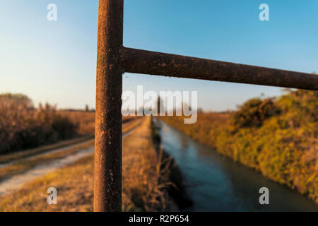 Brücke über einem bewässerungskanal der Lomellina bei Sonnenuntergang Stockfoto