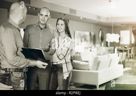 Nach Verkäufer in Möbelhaus Kunden zeigen Produkt Katalog Stockfoto