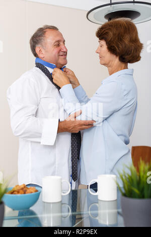 Portrait von positiven reife Frau zu Mann und Einstellen der Riegel zu Hause Stockfoto