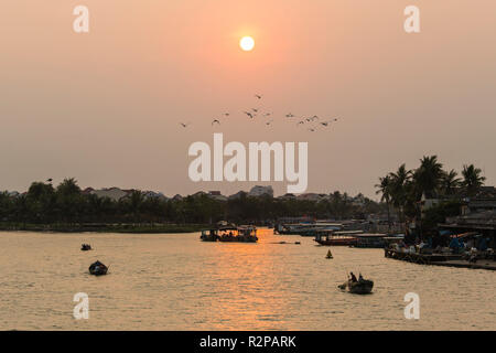 Abendstimmung, niedrige Sonne über Fluss in Hoi An, Vietnam, Rückkehr Fischerboote Stockfoto