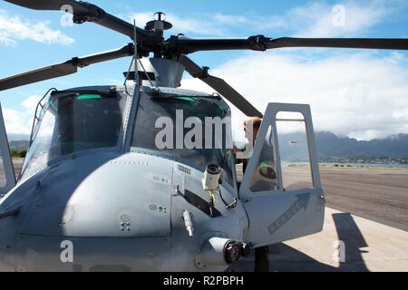 Us Marine Kapitän Steve Vining, ein Pilot mit Marine Light Attack Helicopter Squadron 367, zeigt Schauspieler Stephen Hill um Ein UH-1Y Huey Hubschrauber, auf Marine Corps Base Hawaii, November 2, 2018. Hügel spielt eine ehemalige Marine Huey Pilot als Theodore 'TC' Calvin auf der TV-Serie Magnum P.I. Stockfoto