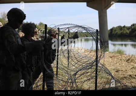 Soldaten concertina Draht in eine Position entlang der südwestlichen Grenze der Vereinigten Staaten in der Nähe von Hidalgo, Texas bereitstellen. Us-Armee Norden ist unter der Aufsicht des US Northern Command an der südwestlichen Grenze das Ministerium für Heimatschutz und der Zoll und Grenzschutz Mission der Grenze zu unterstützen. November 2, 2018. Stockfoto