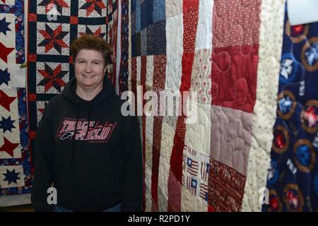 Master Sgt. Lynn Koger, Gerät Training Manager 133 Test Squadron der Iowa Air National Guard in Fort Dodge, Iowa steht vor ein paar patriotische Steppdecken auf Anzeige an einem Quilt Show in Fort Dodge, Iowa am 26. Oktober 2018. Koger, die Steppdecken, während sie in den Irak bereitgestellt wurde und Pläne, um die steppdecken der Valor Programm zu spenden. Steppdecken der Valor stellt Steppdecken zu militärischen US-Mitglieder, die durch den Krieg berührt wurden. Us Air National Guard Stockfoto
