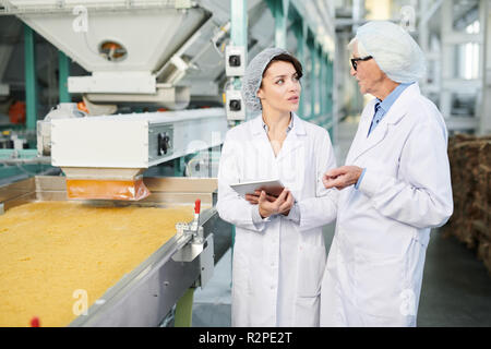 Zwei weibliche Arbeitnehmer beaufsichtigen die Nahrungsmittelproduktion Stockfoto