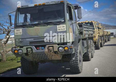 Us Army M1083 A1P2 Medium taktische Fahrzeuge, die durch US-Soldaten der Saipan National Guard betrieben werden vorbereitet, Wasser und Nahrung zu den Einheimischen von Saipan den Transport nach Super Typhoon Yutu, November 4, 2018. Service Mitglieder aus der gemeinsamen Region Marianas und US-Indo-Befehl sind, Verteidigungsministerium, Unterstützung der Zivilgesellschaft und lokalen Beamten der CNMI als Teil der FEMA-unterstützte Super Typhoon Yutu Recovery Effort. Stockfoto