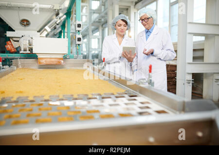 Zwei Arbeiter die Überwachung der Produktion von Lebensmitteln Stockfoto