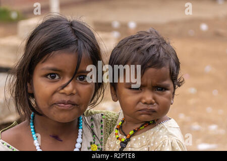 Angadihalli, Karnataka, Indien - November 2, 2013: Dual face closeup von jungen Mädchen ihre jüngere Schwester, die auf ihrem Arm. Sowohl schwarze Haare mit werden. Stockfoto