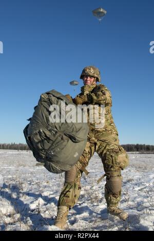 Armee Pfc. Kathleen Klink, zu B Unternehmen zugewiesen sind, 6. Brigade Engineer Brigade Engineer Battalion, 4th Infantry Brigade Combat Team (Airborne), 25 Infanterie Division, U.S. Army Alaska, lädt Ihr Fallschirm erholt Pack nach erfolgreich springen von einem CH-47 Chinook Hubschrauber Joint Base Elmendorf-Richardson, Alaska, November 1, 2018. Die Soldaten der 4/25 gehören zu den nur American Airborne Brigade im Pazifik und sind geschult in der Luft Manöver bei extrem kalten Wetter und Höhenlage Umgebungen zur Unterstützung der Bekämpfung, Partnerschaft und Katastrophenhilfe Operationen auszuführen. Heeresflieger f Stockfoto