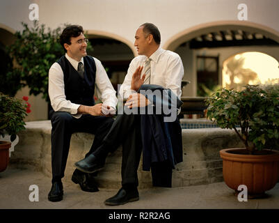 Zwei Geschäftsleute ein Gespräch haben, wie Sie in der Nähe der Brunnen sitzen. Stockfoto