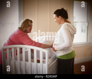 Seitliche Sicht auf eine Krankenschwester untersuchen eine schwangere Frau. Stockfoto