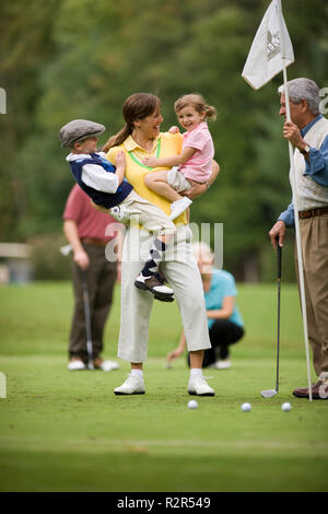 Mutter, die zwei Kinder auf Golfplatz Stockfoto