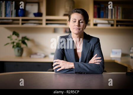 Mitte - Erwachsene Geschäftsfrau schiefen ihre Arme auf dem Schreibtisch überquert beim Sitzen mit Ihren Augen in ihrem Büro geschlossen. Stockfoto
