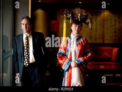 Porträt eines jungen erwachsenen Frau in traditioneller Kleidung mit einem mittlerem - Erwachsene Geschäftsmann. Stockfoto