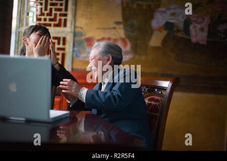 Ältere Frau und junge Frau zusammen an einer Chinesischen cafe Lachen. Stockfoto