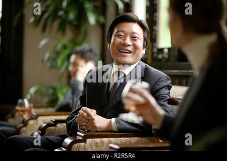 Reifen erwachsenen Geschäftsmann sitzen und Lachen mit einem Kollegen. Stockfoto