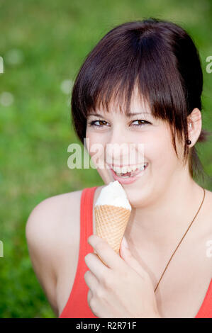 Junge Frau ist Eis essen Stockfoto