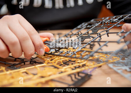 Ist ein Junge hand Montage Modelle aus Kunststoff mit Werkzeugen. Stockfoto