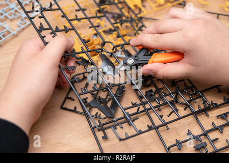 Ist ein Junge hand Montage Modelle aus Kunststoff mit Werkzeugen. Stockfoto