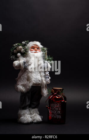 Santa Claus Spielzeug mit einem motivierenden Jar für Weihnachten Urlaub. Glaube an die Magie von Dezember jolly Saison Stockfoto