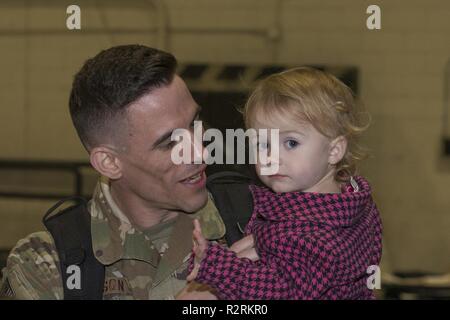 Einen Flieger von der 726th Air Control Squadron kehrt von der Bereitstellung und hält sein Kind. Über 100 Piloten aus der 726th ACS eingesetzt mit der Aufgabe der Unterstützung der Kommunikation zwischen Luft- und Bodeneinheiten. Stockfoto