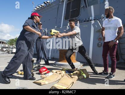 PEARL HARBOR (Nov. 4, 2018) Major League Baseball (MLB) Spieler Juan Soto (links) und Amed Rosario (rechts) erhalten eine Marine infrarot Wärmebildkamera bei ihrem Besuch an Bord der Arleigh-Burke-Klasse zu testen geführte Anti-raketen-Zerstörer USS Wayne E.Meyer (DDG108) während einer Tournee Joint Base Pearl Harbor-Hickam. Die MLB Spieler nahm auch an einer Vereinigten durch Lesen Veranstaltung durch das Lesen für die Kinder der Mitglieder. Stockfoto