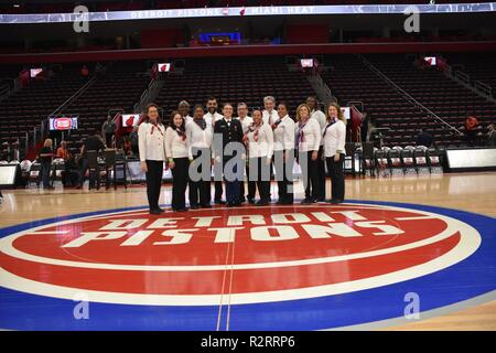 Michigan Army National Guard Soldat SPC. Samantha Hall und der Detroit Arsenal Einheit Team Chor nur nach der Generalprobe für das Singen der Nationalhymne bei den Detroit Pistons' Hoops für Spiel Truppen gegen die Miami Heat 5. November an der Little Caesars Arena in Detroit, Michigan. Der Chor besteht aus ehrenamtlichen Mitarbeitern aus den Detroit Arsenal. Stockfoto