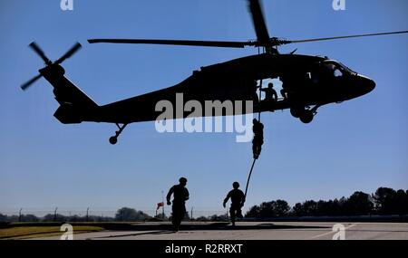 Eine Gruppe von US-Army Rangers, 5 Ranger Training Bataillon zugeordnet, führt eine schnelle Seil Einsetzen/Ausziehen (Pommes) außerhalb des UH-60 Black Hawk Hubschrauber, während Pommes/Spione Ausbildung bei der Army Aviation Support Facility, Winder, GA., 2. November 2018 zu Charlie Company, 1st Battalion, 106Th Aviation Regiment zugeordnet. Diese Schulungen können sowohl Piloten und Soldaten perfekt Ihre Fähigkeiten für zukünftige Erfolg der Mission vorzubereiten. Stockfoto