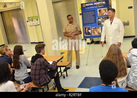 JACKSONVILLE, Fla. (Nov. 7, 2018) - Naval Hospital Jacksonville lt Marissa Ghant, eine Familie Medizin Arzt, und Cmdr. Octaviano Espinosa, ein ob - gyn Arzt, diskutieren Navy Medical Corps Karrierewege mit Darnell-Cookman Schule der Medizinischen Künste 9. und 10. Grader während Wissenschaft des Krankenhauses, Service, Medizin und Mentoring (S2 M2) Programm kick-off am 07.11.7 an der Schule. NH Jacksonville hat die S2M2-Programm im Jahr 2010 und hat 72 Darnell-Cookman Studenten am Krankenhaus für Sommer Praktika. Stockfoto