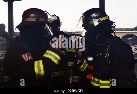 POLARIS (Nov. 8, 2018) - Departement für Verteidigung zivile Feuerwehrmänner, zu Naval Base Guam zugeordnet, ihre Selbst hinzufügen - Atemschutzgerät Regulierungsbehörden zu ihrem Gesicht Masken enthalten sind, während ein integriertes Brandschutzübung mit dem u-boot Tender USS Frank Kabel (wie 40), 8. Frank Kabel, Vorwärts - nach Guam, Reparaturen, rearm bereitgestellt und reprovisions eingesetzten US-Seestreitkräfte im Indo-pazifischen Region. Stockfoto