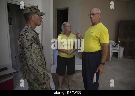 Petty Officer 3rd Class William Mathis, ein Erbauer bau Mann mit Naval Mobile Konstruktion Bataillon 1, spricht mit Tinian Bewohner während der US-Verteidigung Unterstützung der zivilen Behörden Hilfsmaßnahmen auf Tinian, Commonwealth der Nördlichen Marianen, November 6, 2018. Unternehmen, staatliche Gebäude, Häuser und Schulen wurden stark von Super Typhoon Yutu, die einen direkten Treffer mit verheerenden Auswirkungen auf Tinian Okt. 25 Wie der Zweitstärksten Sturm zu je US-Boden Hit gemacht beschädigt. Marines mit dem 31 Marine Expeditionary Unit und zur Bekämpfung der Logistik Bataillon 31 auf Tinian Okt. 29-31 angekommen Stockfoto