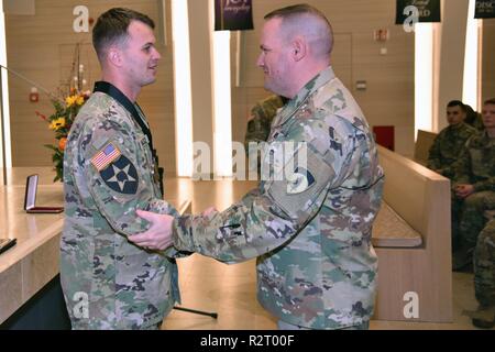 Sgt. Maj. David Clark, die US-Army Europe chief für religiöse Angelegenheiten Sergeant Major, stellt Personal. Sgt. Aaron Madasz, 2.Kavallerie Regiments, mit der ersten Staff Sgt. Christopher Stout Medal unterzeichnet durch den Leiter der Kapläne, November 7, 2018. Stockfoto