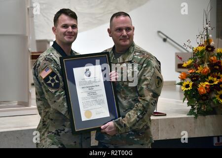 Sgt. Maj. David Clark, die US-Army Europe chief für religiöse Angelegenheiten Sergeant Major, stellt Personal. Sgt. Aaron Madasz, 2.Kavallerie Regiments, mit der ersten Staff Sgt. Christopher Stout Medal unterzeichnet durch den Leiter der Kapläne, November 7, 2018. Stockfoto