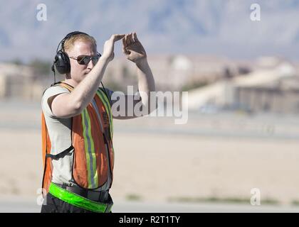 Staff Sgt. Guy Hinton, F-22 Raptor fighter Jet engagierte Crew Chief auf der 57. Tagung der Aircraft Maintenance Squadron zugeordnet, spricht mit der Pilot einer F-22 Raptor fighter Jet auf der Nellis Air Force Base, Nevada, November 5, 2018. Die Betankung war im 3 Bombardierung pad Aufgrund der Gefahren des Durchführen einer Hot-grube Betankung durchgeführt. Stockfoto