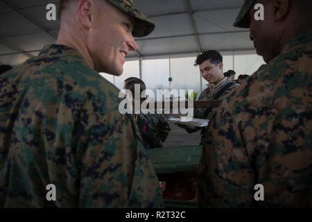 Us Marine Corps Maj Duane Kortman, links, mit 2 Marine Logistik Group-Forward und 1 Sgt. Nicholas Underwood, rechts, der Sergeant Major der Bekämpfung Logistik Bataillons 251, 2 Marine Logistik Group-Forward, servieren Mittagessen während der im Marine Corps Geburtstagsfeier an einem Marine Corps Vorpositionierung Program-Norway Lage, Nov. 10, 2018. Die Marines hosted a Marine Corps Geburtstagsfeier mit einem traditionellen Kuchen schneiden und Mittagessen während der Übung Trident Zeitpunkt 18. Die Übung verbessert die USA und die NATO-Verbündeten und Fähigkeiten der Partner zur Zusammenarbeit mi zu leiten Stockfoto