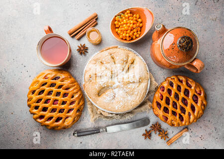 Verschiedene hausgemachte Kuchen mit Zutaten. Crostata - offene Berry pie und Apfelkuchen auf eine Tabelle, Ansicht von oben, von oben Stockfoto