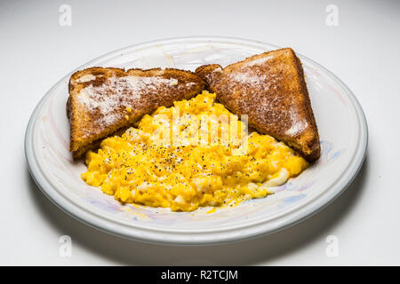 Rührei zwei gebuttertem Toast Weizen Stockfoto