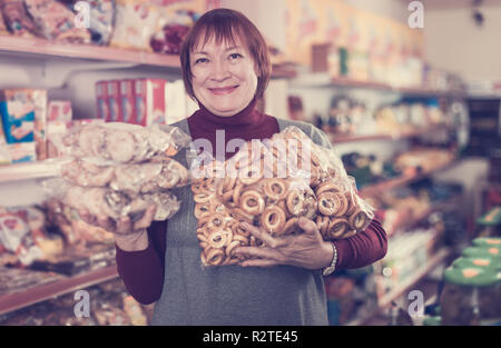 Positive ältere Frau Verbraucher mit Backwaren in der Lebensmittel Shop Stockfoto