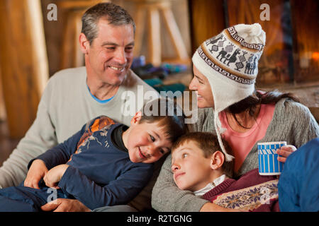 Glückliche Familie zusammen zu sitzen mit den Armen um sich. Stockfoto