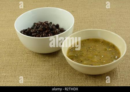 Zutaten für die mexikanische Küche der schwarzen Bohnen und Salsa verde in weißen Schalen Stockfoto