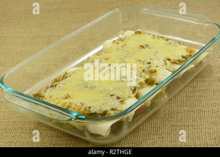 Gebackenes Huhn und Bean enchildas in Salsa verde und Käse in Glas Auflaufform erstickt Stockfoto