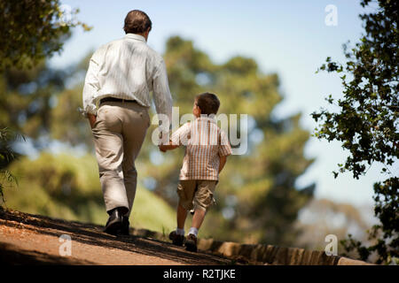 Vater und Sohn gehen Hand in Hand. Stockfoto