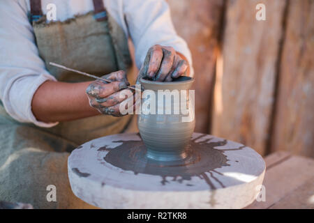 Potter ist das Erstellen von Steingut auf der Töpferscheibe. Stockfoto