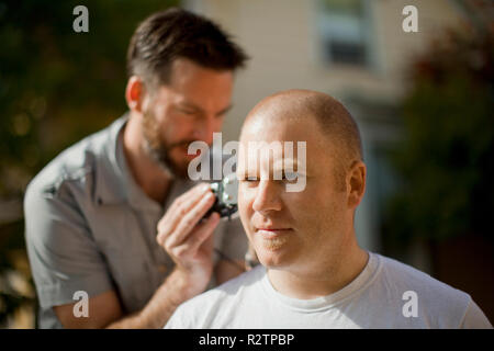 Mann Scherkopf eines anderen Mannes. Stockfoto