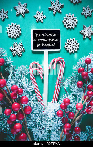 Vertikale schwarze Zeichen mit englischen Zitat Es ist immer ein guter Zeitpunkt, um zu beginnen. Weihnachtsdekoration, wie Fir Tree Branch, Candy Sticks, Schneeflocken und Sta Stockfoto