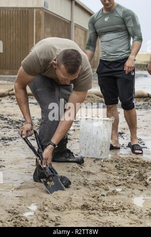 Ein- und Ausschalten - Pflicht Soldaten der 34th Red Bull Infanterie Division bei Flut Antwort Bemühungen auf Camp Arifjan in Kuwait. Historische Niederschläge und Überschwemmungen in Kuwait hat die Region in den letzten Wochen gequält. Wie die Wüste Boden kämpfe Regenwasser aufzunehmen, Stürme zu bestehen. In den letzten 24 Stunden, Kuwait empfing mehr Niederschlag als im Land Erfahrungen in einem typischen Jahr. Straßen, darunter Dutzende von den wichtigsten Autobahnen und den Flughafen flightlines in Kuwait geschlossen haben, lassen viele Reisende gestrandet. Red Bull Soldaten, die im Camp Arifjan stationiert sind beim Einsatz in der Task Force Spar Stockfoto