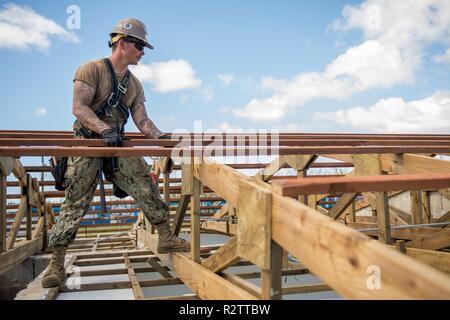 TINIAN, Commonwealth der Nördlichen Marianen (Nov. 14, 2018) Builder 3. Klasse William Mathis, zu Naval Mobile Konstruktion Bataillon 1, Loslösung Guam, von Ragland, Ala zugeordnet, Orte eine pfette auf dem Dach der Volksschule während der Wiederherstellung Tinian Bemühungen. Service Mitglieder aus der gemeinsamen Region Marianas und US-Indo-Befehl sind die Verteidigungsministerium Unterstützung des Commonwealth von zivilen und lokalen Beamten der Nördlichen Marianen" als Teil der Federal Emergency Management Agency - unterstützt Super Typhoon Yutu Wiederaufnahme Bemühungen. Stockfoto