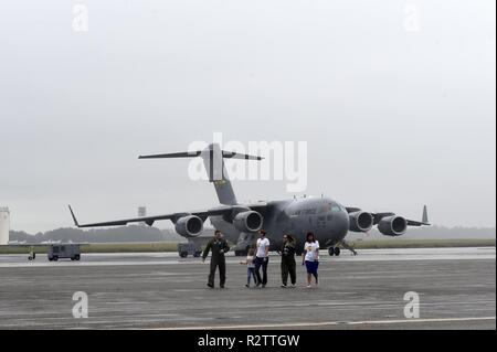 Fallon Schmirgel, zweiter von rechts, ein neues Ehrenmitglied der 437th Operations Support Squadron, Spaziergänge auf dem Flug mit 1 Lt Thad Sollick, Links, eine C-17 Globemaster III Pilot die 437th OSS, Nov. 7, 2018 zugewiesen, nachdem an Joint Base Charleston, S.C. touring Eine C-17, als Teil der Pilot für einen Tag Programm. Während ihres Besuchs wird die 14-jährige Emery tourte auch eine C-17 Flight Simulator, night vision und andere militärische Technik gelernt, eine Beseitigung von Explosivstoffen Roboter gesteuert und traf mit 437Th Airlift Wing Senior Leaders. Der Flieger für einen Tag Programm erkennt die Widerstandsfähigkeit Stockfoto