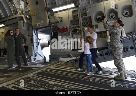 Fallon Emery, ein neues Ehrenmitglied der 437th Operations Support Squadron, Posen für Fotos mit 1 Lt Thad Sollick, eine C-17 Globemaster III Pilot die 437th OSS zugeordnet, innerhalb einer C-17 Nov. 7, 2018, in gemeinsamen Basis Charleston, S.C., als Teil der Pilot für einen Tag Programm. Während ihres Besuchs wird die 14-jährige Emery tourte auch eine C-17 Flight Simulator, night vision und andere militärische Technik gelernt, eine Beseitigung von Explosivstoffen Roboter gesteuert und traf mit 437Th Airlift Wing Senior Leaders. Der Flieger für einen Tag Programm erkennt die Resilienz von Kindern dar, die verschiedenen Krankheiten Stockfoto