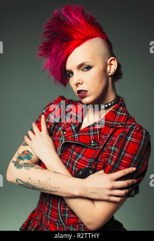 Portrait zuversichtlich, coole junge Frau mit rosa Mohawk und Tattoos Stockfoto